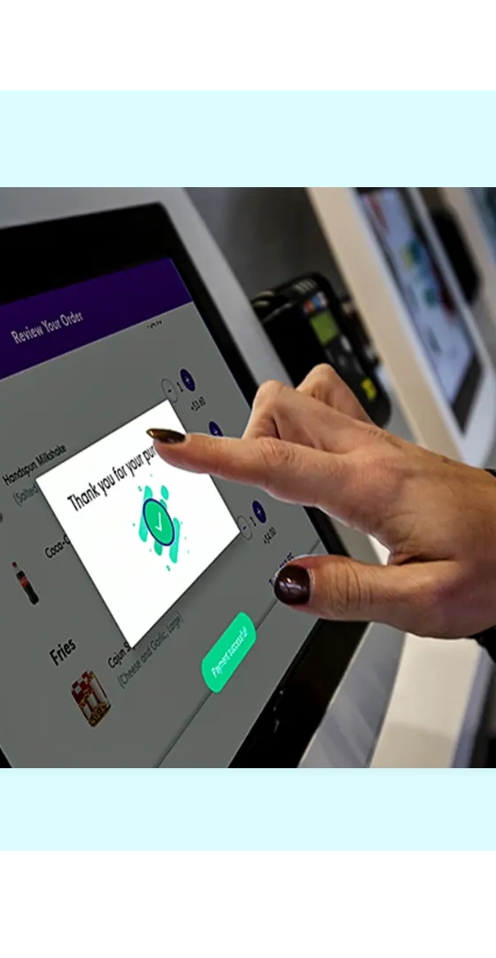 Customer tapping a FaciliPay self-service ordering kiosk to review an order and confirm a purchase.