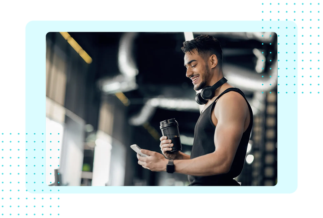Man using his phone at the gym, representing FaciliPay fitness and wellness payments.