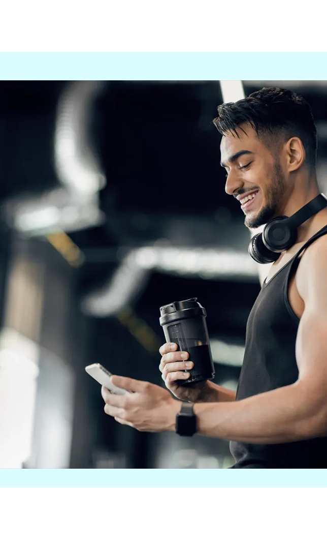 Man using his phone at the gym, representing FaciliPay fitness and wellness payments.