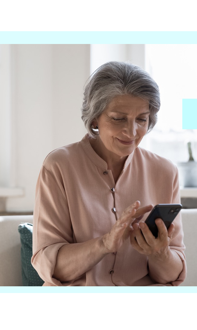Older woman at home using her phone, representing FaciliPay payment solutions for healthcare and care settings.