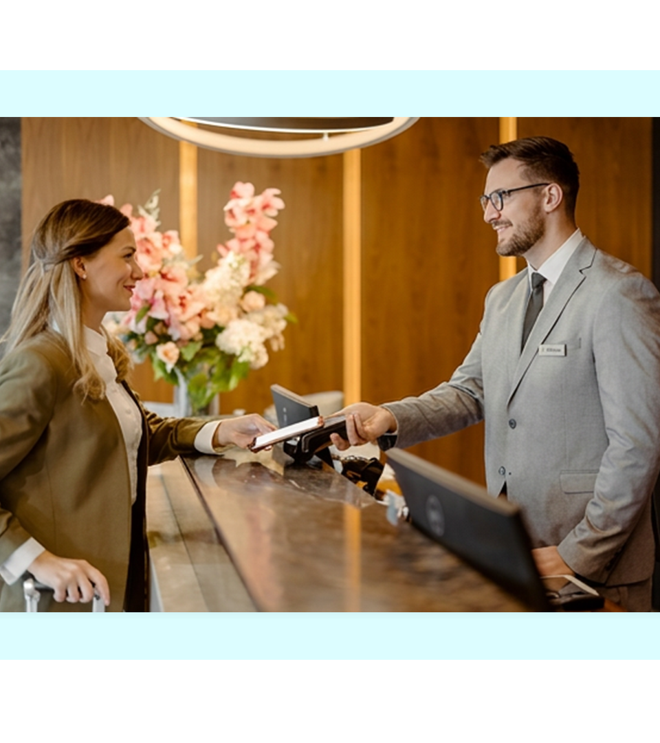Hotel guest making a contactless payment at a reception desk, representing FaciliPay payment solutions for hospitality and hotels.