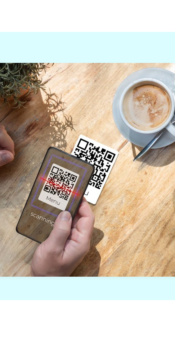 Diner scanning a QR code menu at a café table with coffee and juice, representing FaciliPay QR table ordering.